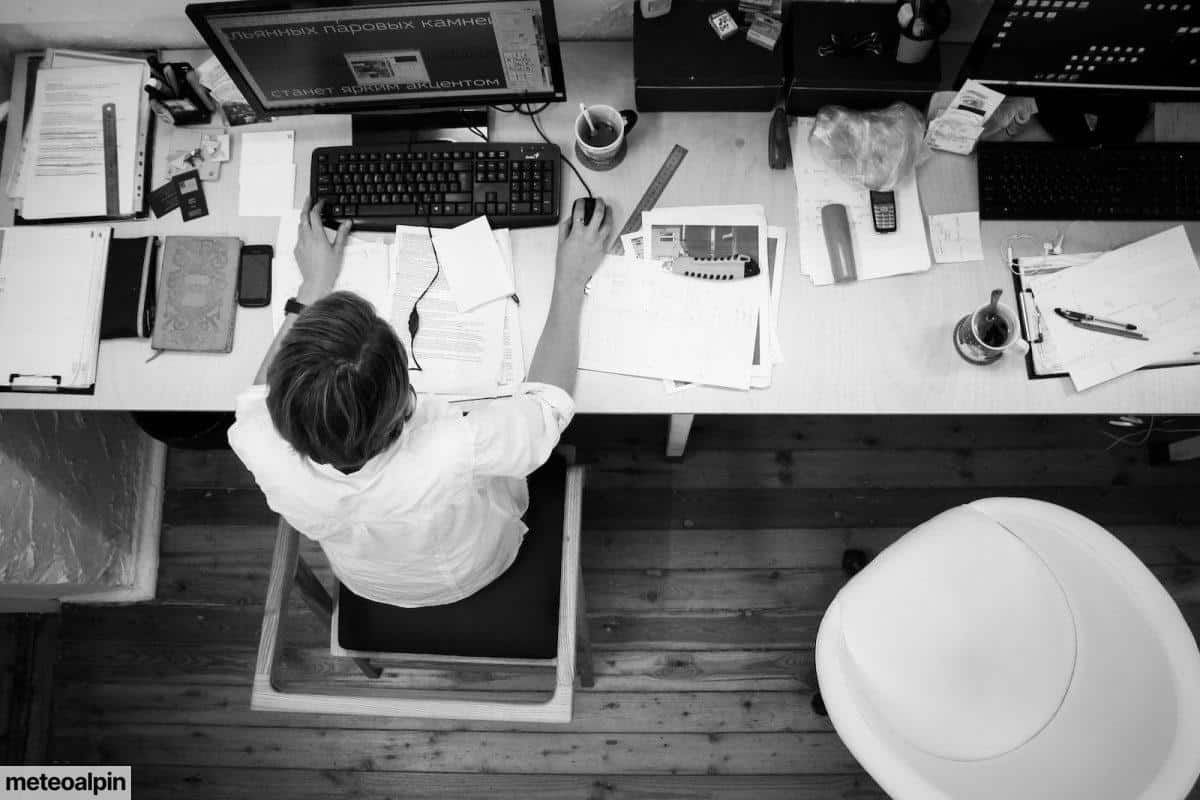Black and Gray Photo of Person in Front of Computer Monitor