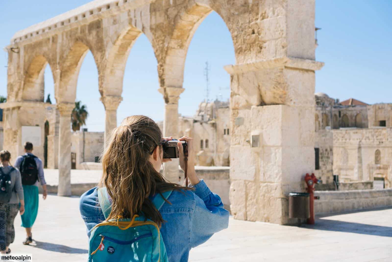 Woman Taking Pictures of Ruins